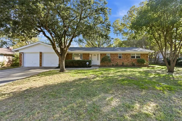 a front view of house with yard and trees