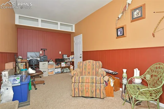 a living room with furniture a rug and a wall painting