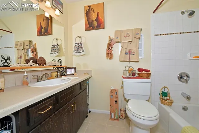 a bathroom with a granite countertop toilet sink and mirror