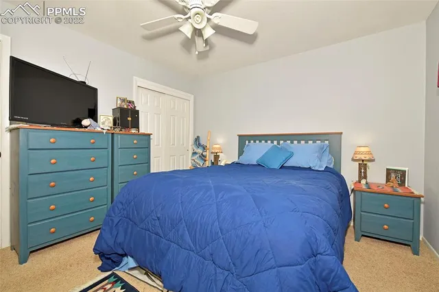 a bedroom with a bed and a flat tv screen on dresser