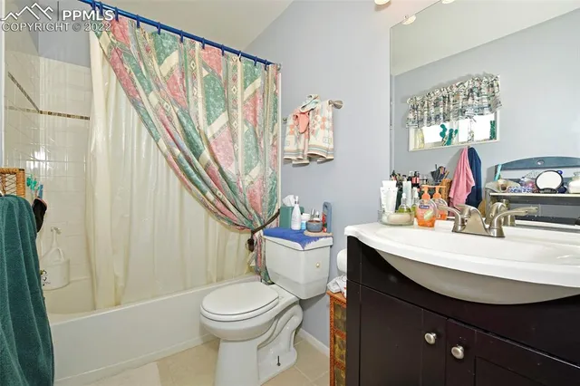 a bathroom with a sink a toilet and shower curtain