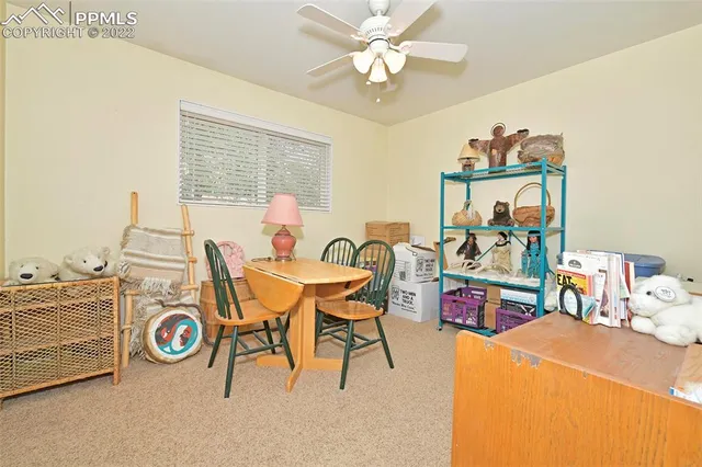 a view of a workspace with furniture and a window