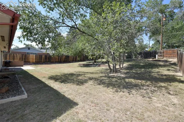 a view of a yard with wooden fence