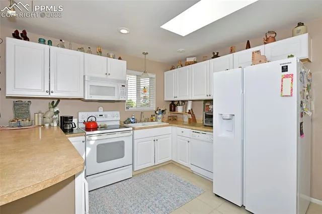 a kitchen with white cabinets and white appliances