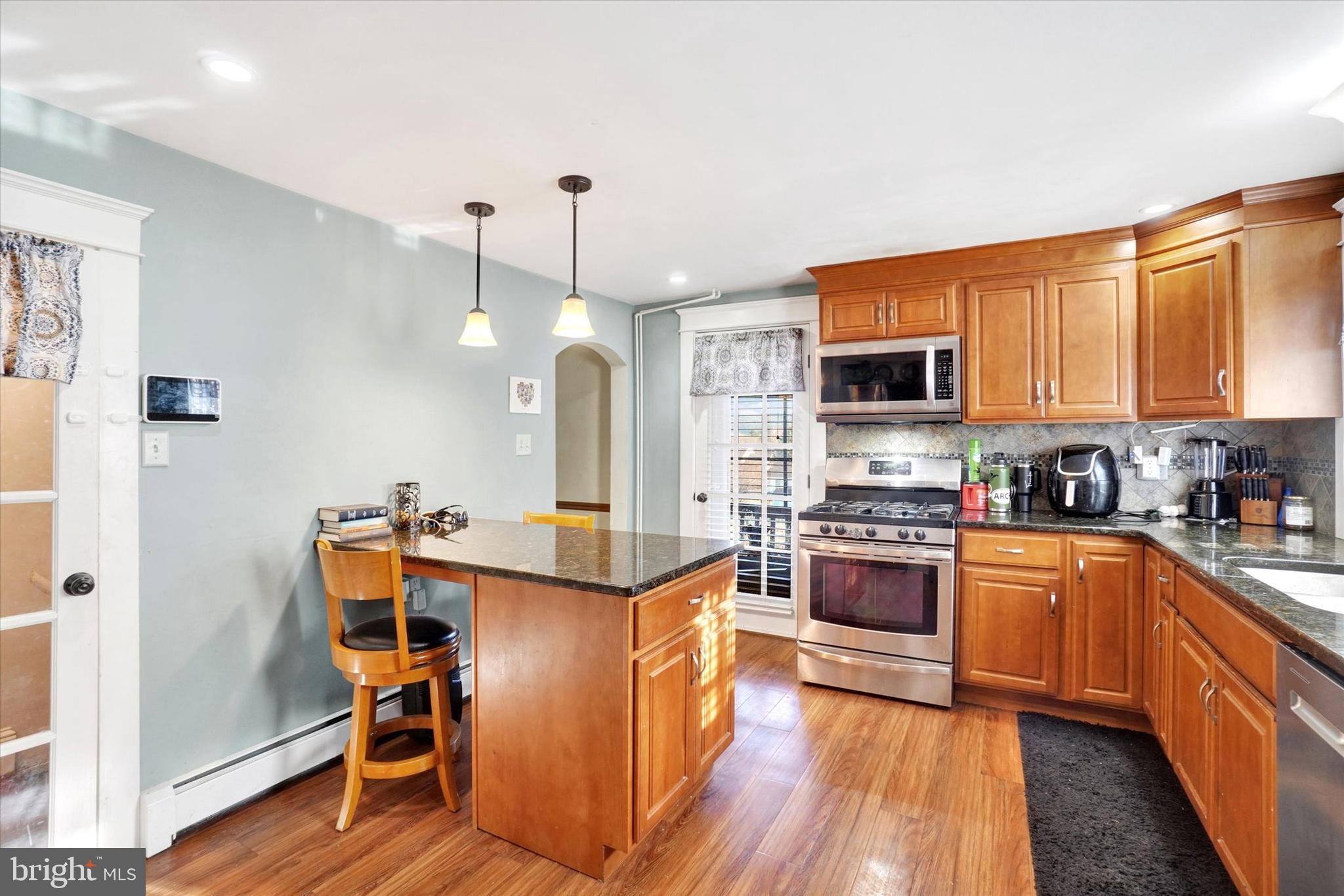 370 East Market Street York, PA 17406 - Photo 9 of 27 a kitchen with stainless steel appliances granite countertop a stove top oven a sink dishwasher and a refrigerator with wooden floor