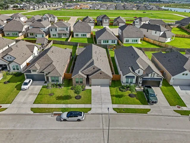 an aerial view of residential houses with outdoor space and parking