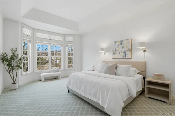 a bedroom with a large bed and a potted plant