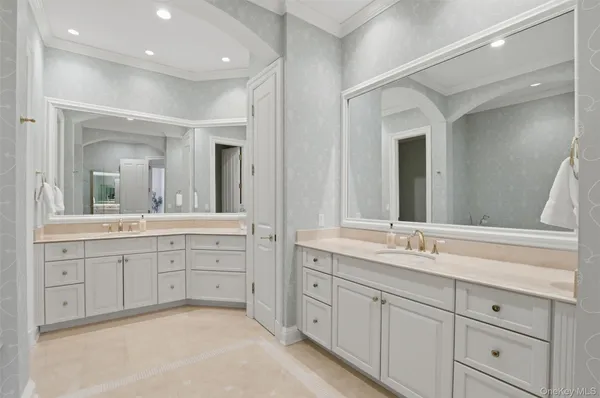 a spacious bathroom with double vanity a mirror and a bathtub
