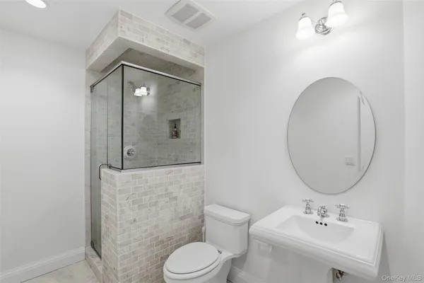 a bathroom with a toilet a sink and mirror