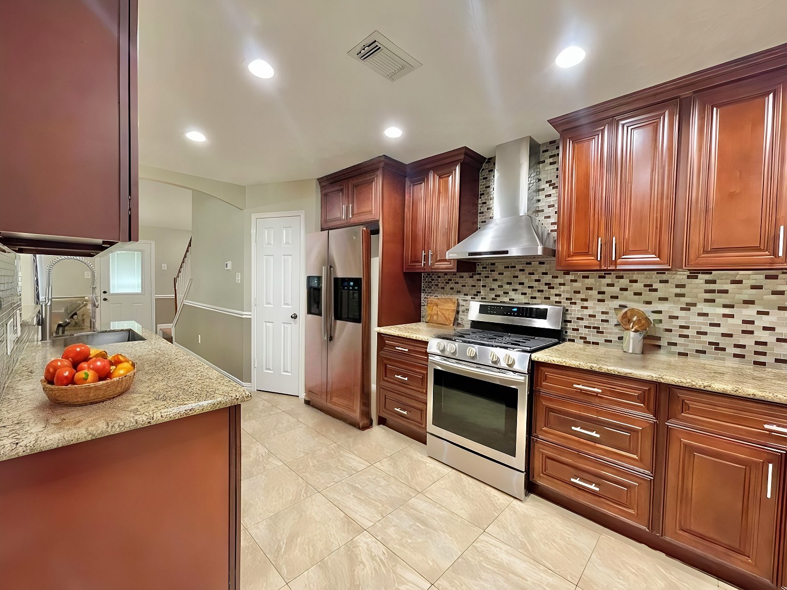 The kitchen is a chef’s delight, featuring tall cabinets, a custom backsplash, and elegant granite countertops.