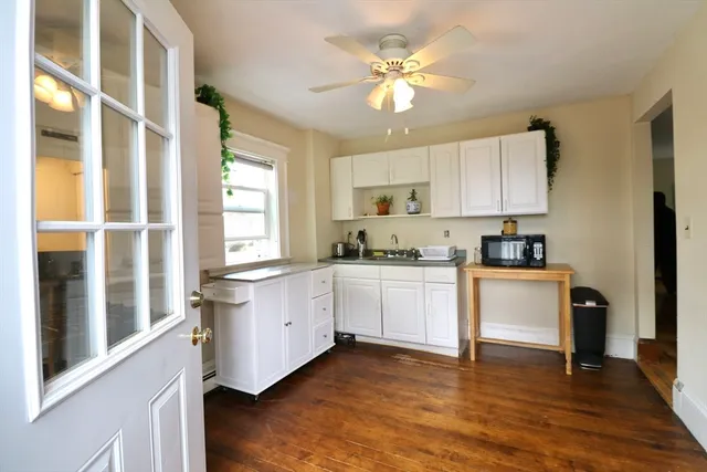 a kitchen with granite countertop white cabinets a sink a window and stainless steel appliances