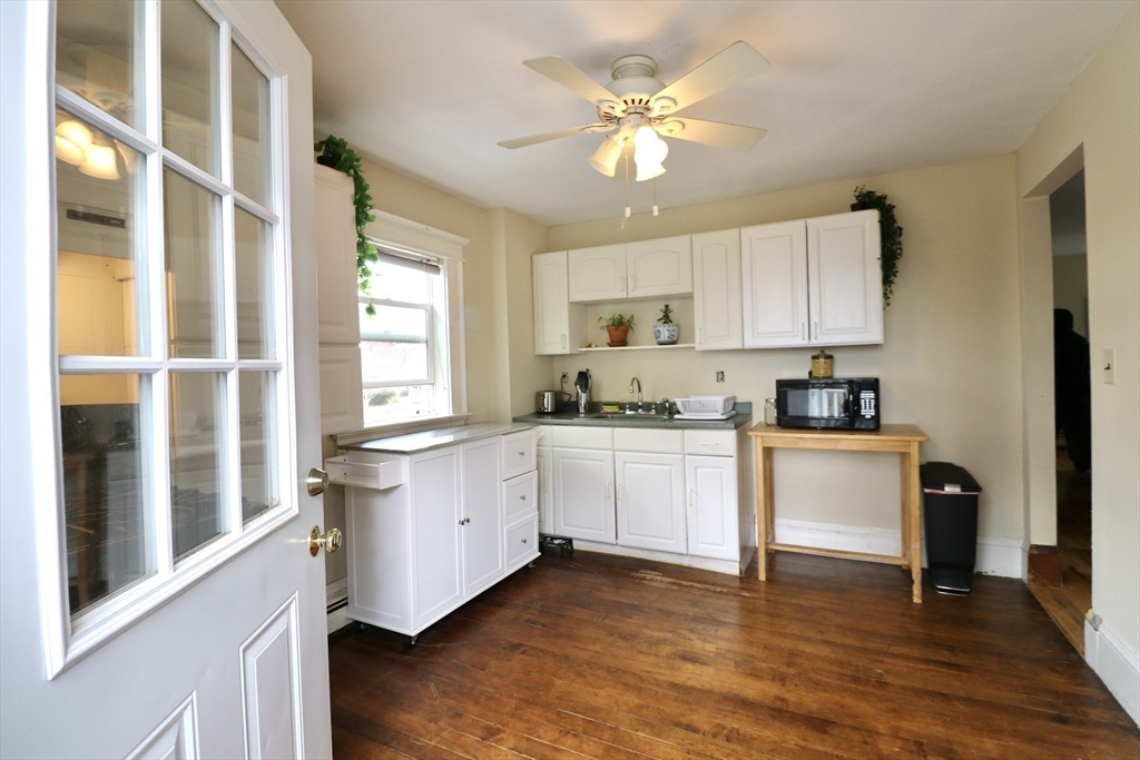 126 Summer Street, Unit 2 Kingston, MA 02364 - Photo 8 of 16 a kitchen with granite countertop white cabinets a sink a window and stainless steel appliances