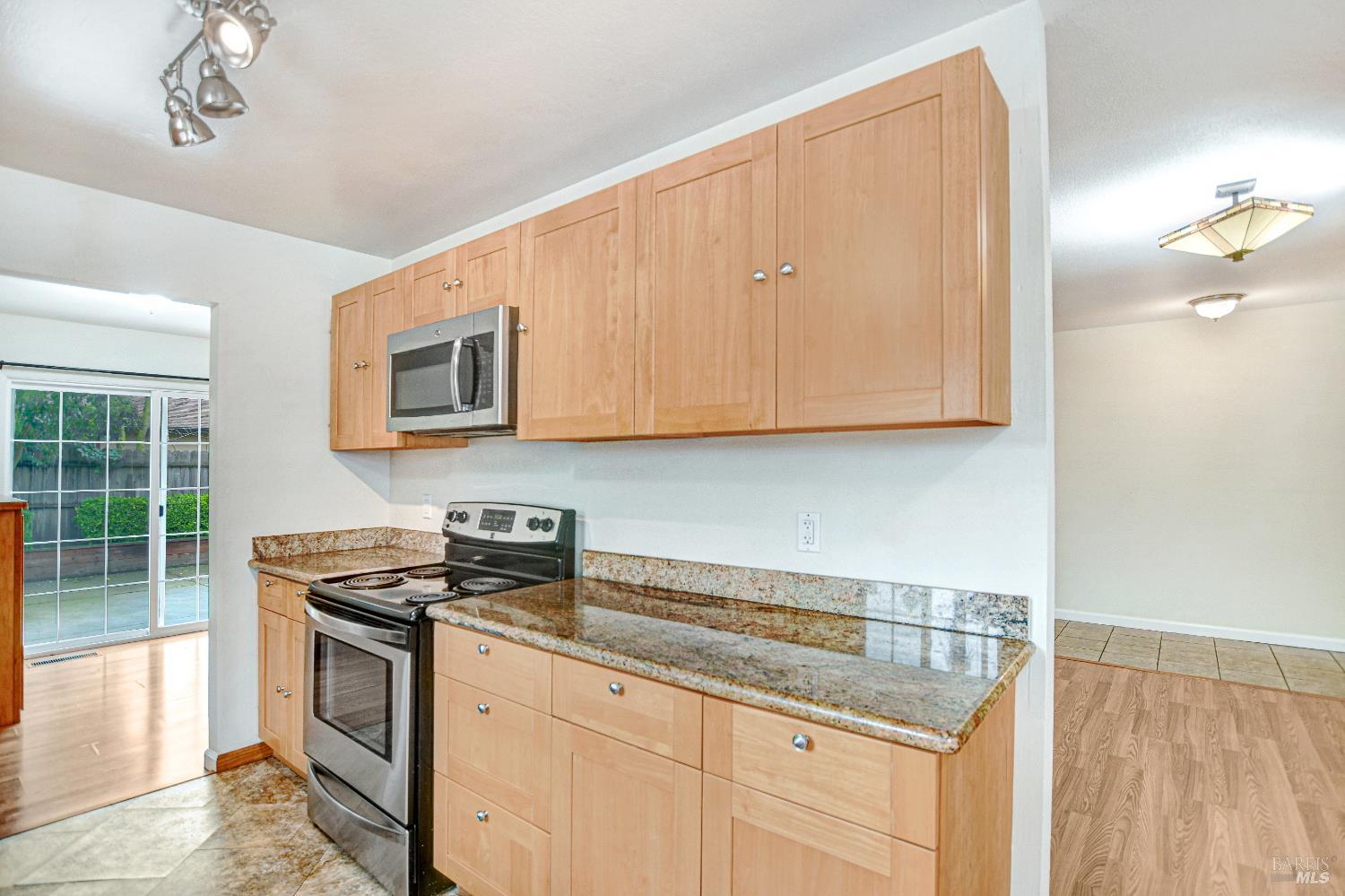 7257 Belita Avenue Rohnert Park, CA 94928 - Photo 12 of 37 a kitchen with stainless steel appliances granite countertop a stove a sink and a microwave