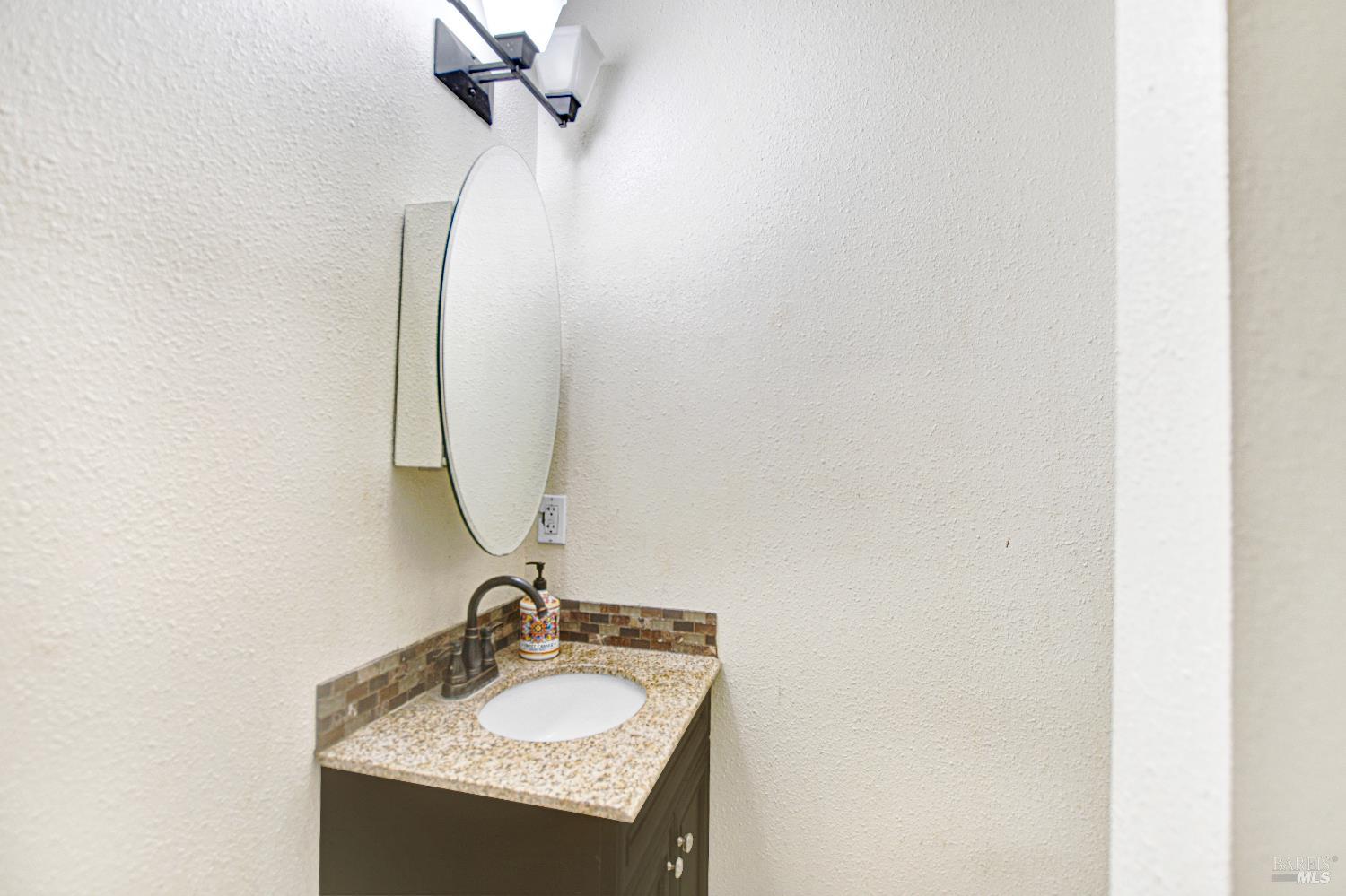 7257 Belita Avenue Rohnert Park, CA 94928 - Photo 20 of 37 a bathroom with a granite countertop sink and a mirror