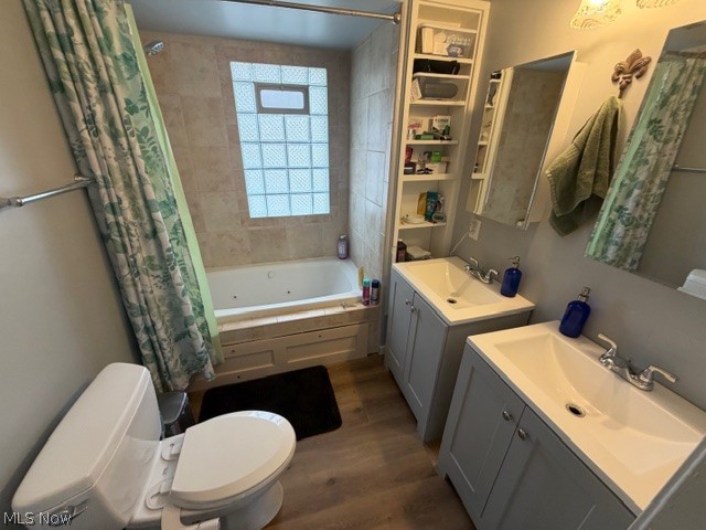 35180 Solon Road Solon, OH 44139 - Photo 19 of 33 Bathroom with two vanities, dark wood-type flooring, and a combined bath / shower with jetted tub