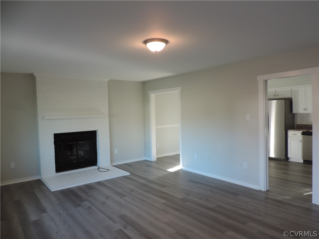 7825 Valencia Road Chesterfield, VA 23832 - Photo 6 of 26 an empty room with wooden floor and fireplace