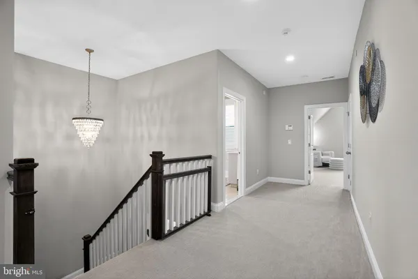 a view of a hallway with stairs to other room