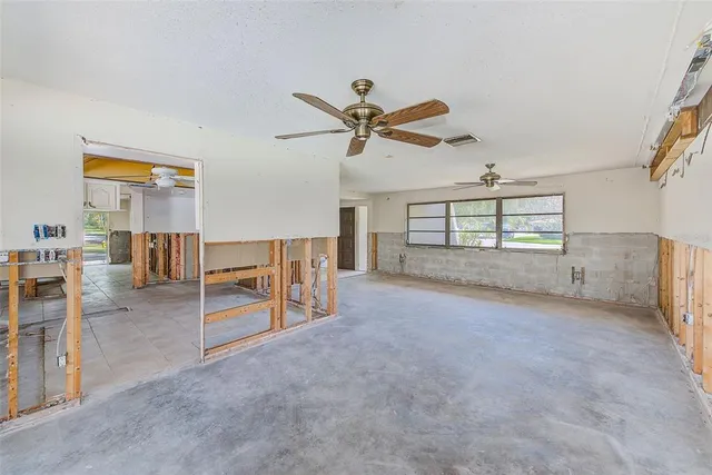 an empty room with furniture and a ceiling fan