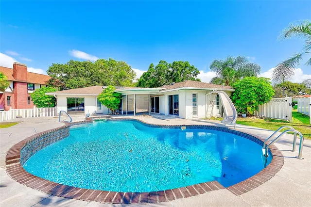 a view of house with swimming pool outdoor seating