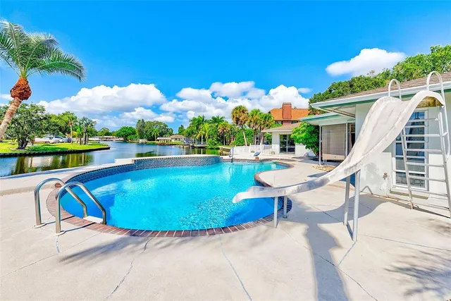 a view of a swimming pool with outdoor seating and plants