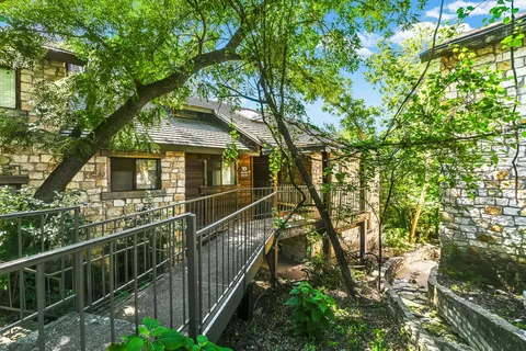 a front view of a house with a tree