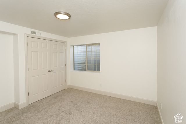 1742 Renaissance Way Springville, UT 84663 - Photo 18 of 23 Recessed window with security bars, light-colored carpeting, white interior walls, overhead flush mount lighting, and bi-fold closet doors