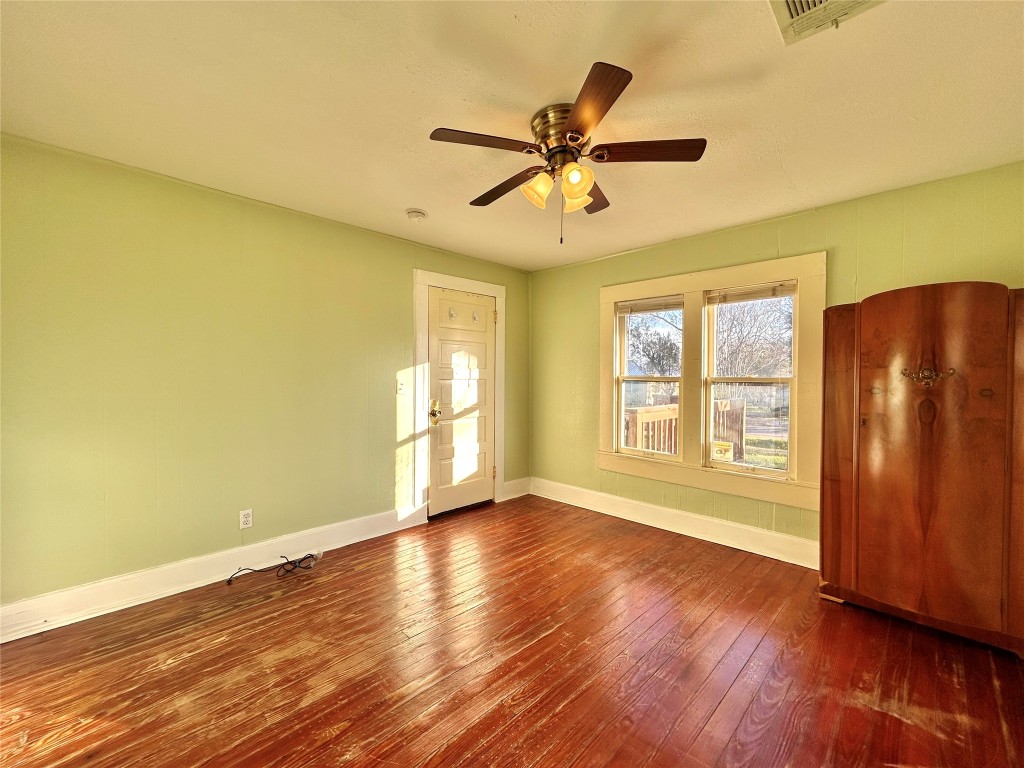 1112 West 3rd Street Taylor, TX 76574 - Photo 19 of 24 Unfurnished room with dark wood-type flooring and ceiling fan