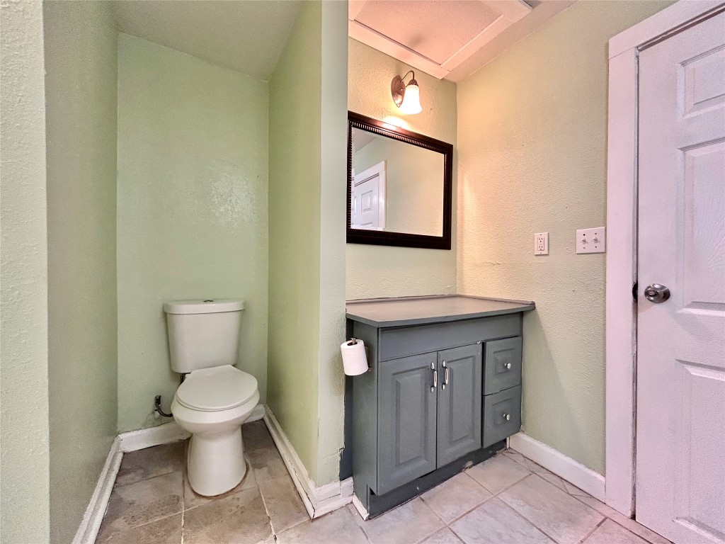 1112 West 3rd Street Taylor, TX 76574 - Photo 22 of 24 Bathroom featuring a textured wall, vanity, and light tile patterned floors