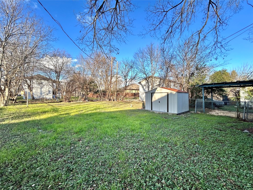 1112 West 3rd Street Taylor, TX 76574 - Photo 6 of 24 Fenced yard featuring a storage unit