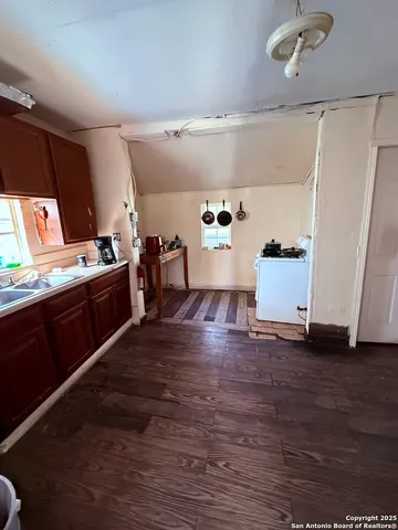 a kitchen with stainless steel appliances wooden floor and a refrigerator
