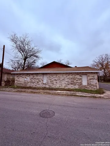 a view of a house with a yard and fence
