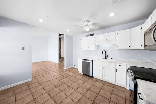 a large white kitchen with cabinets
