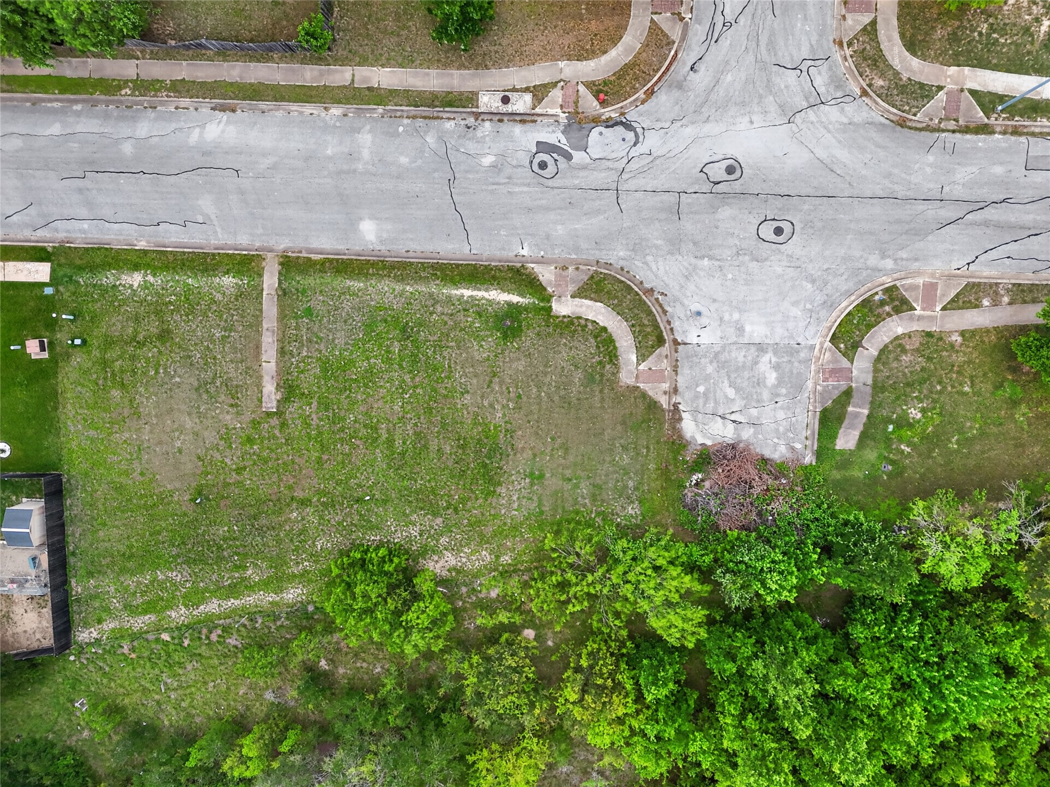 11908 Athens Street Manor, TX 78653 - Photo 11 of 15 An aerial view of the property showcasing a generously sized lot with established trees and a paved street frontage