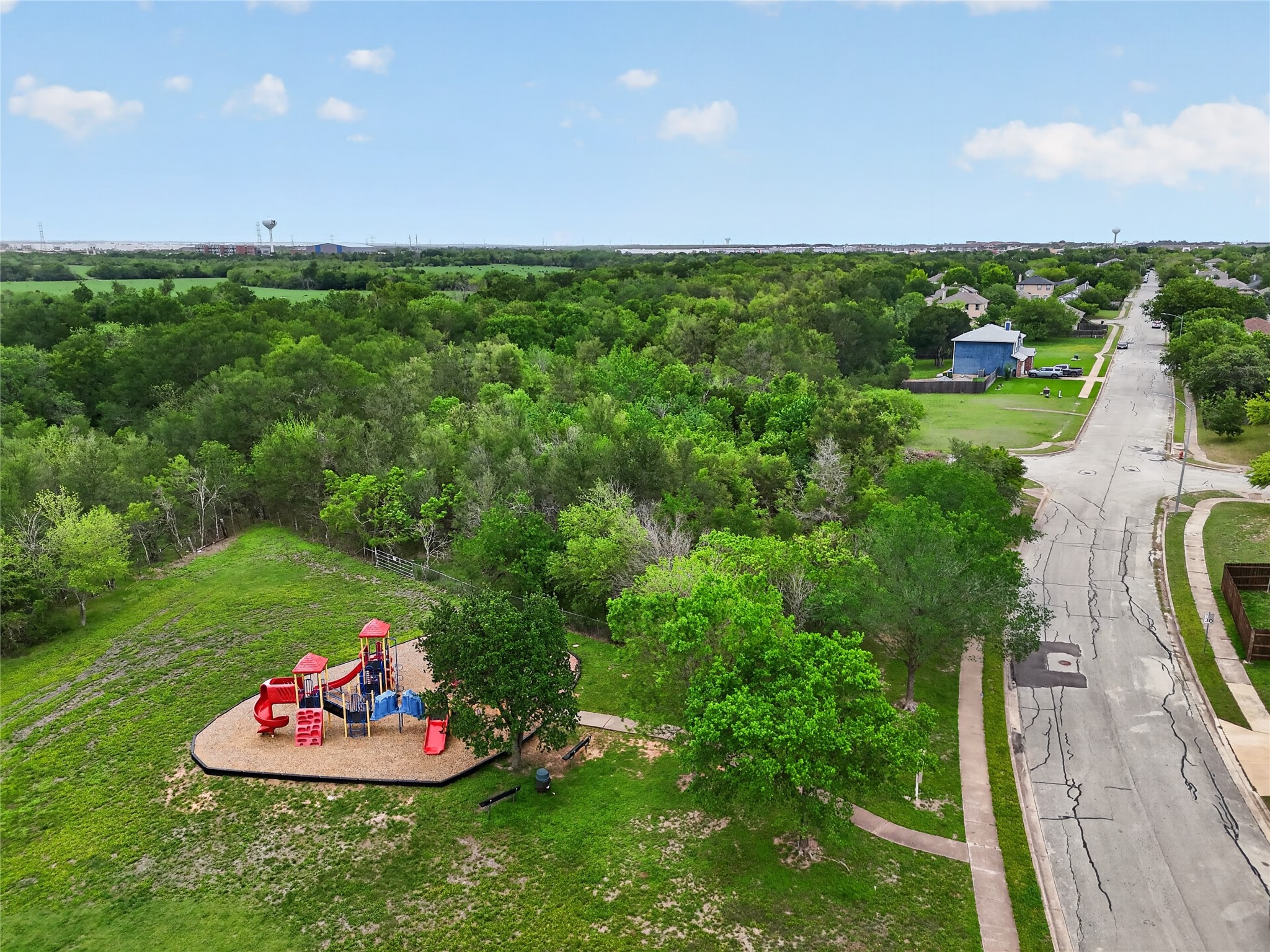 11908 Athens Street Manor, TX 78653 - Photo 13 of 15 The property offers direct access to a playground area with slides, swings, and climbing structures, set amidst a landscape of mature trees and green spaces