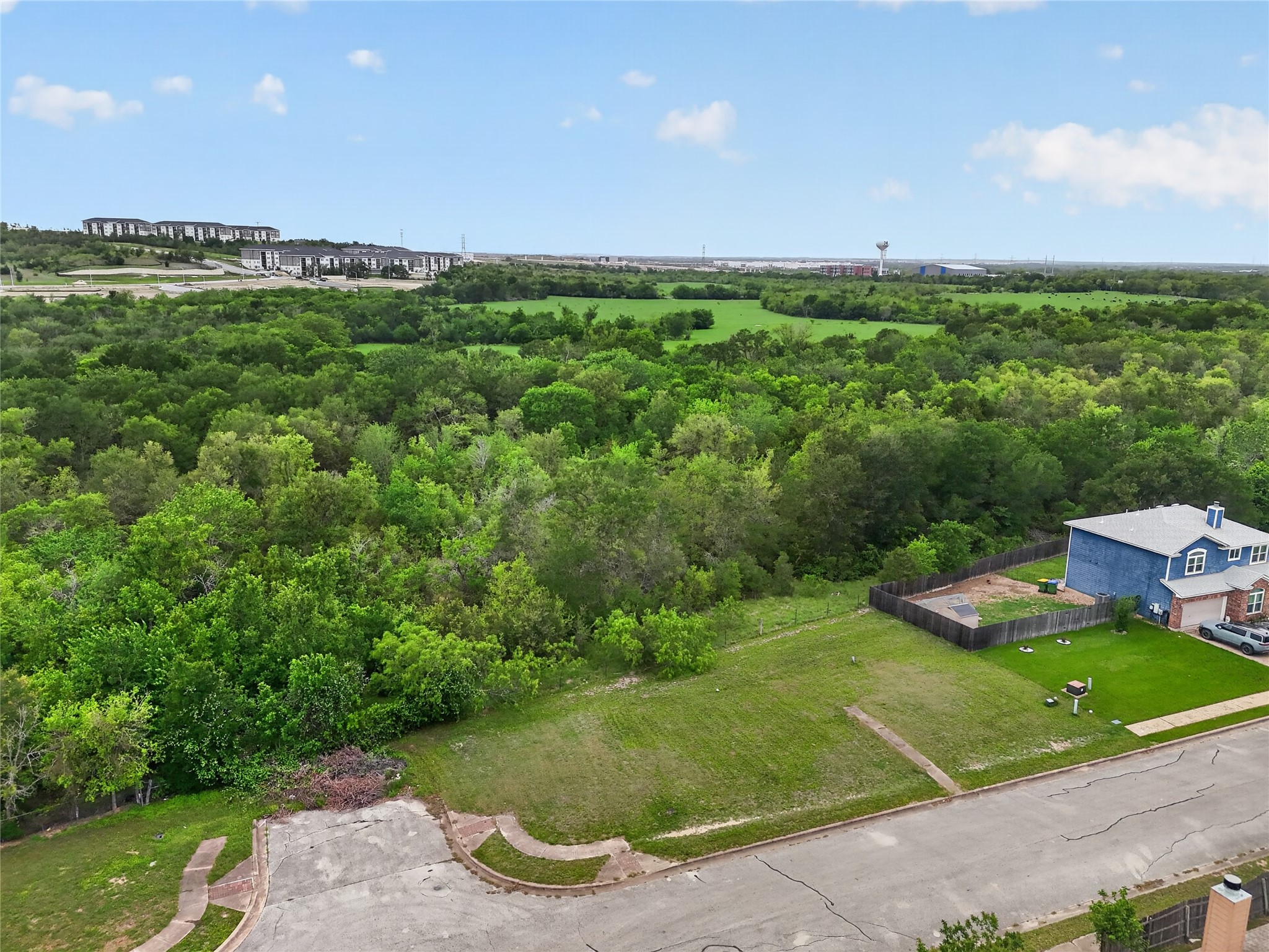 11908 Athens Street Manor, TX 78653 - Photo 8 of 15 Aerial view of the property, featuring a large grassy area and a paved street