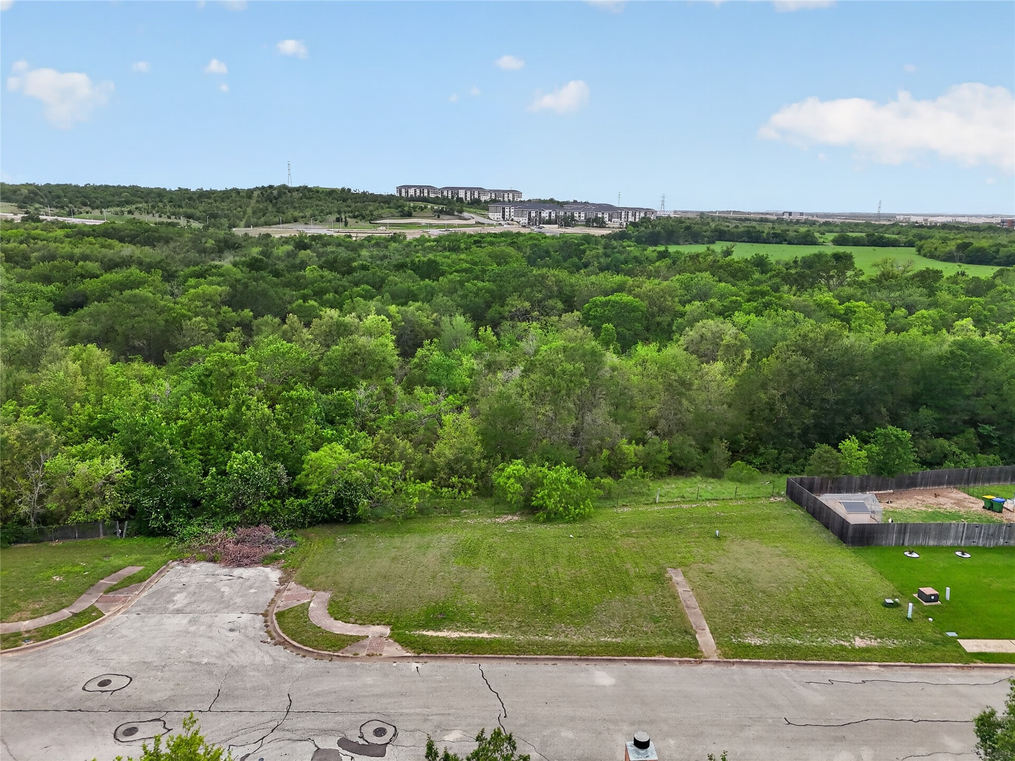 11908 Athens Street Manor, TX 78653 - Photo 9 of 15 Expansive lot featuring a grass lawn and a paved road with curbs