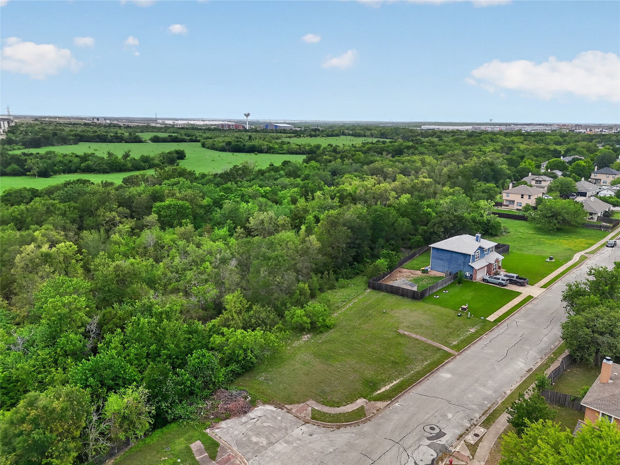 11908 Athens Street Manor, TX 78653 - Photo 10 of 15 Aerial view of the property and its surrounding area, featuring extensive green spaces and a residential street