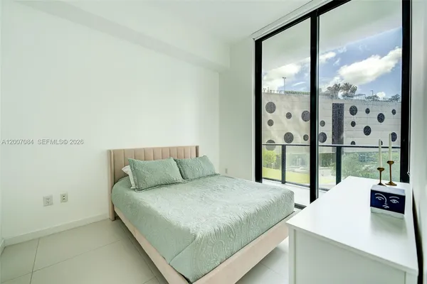 a bedroom with a large bed and a window