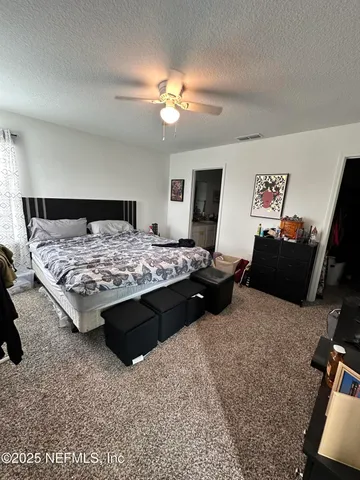 a bedroom with a bed and dresser with mirror