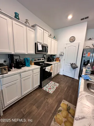 a kitchen with stainless steel appliances granite countertop a stove a sink dishwasher and a microwave