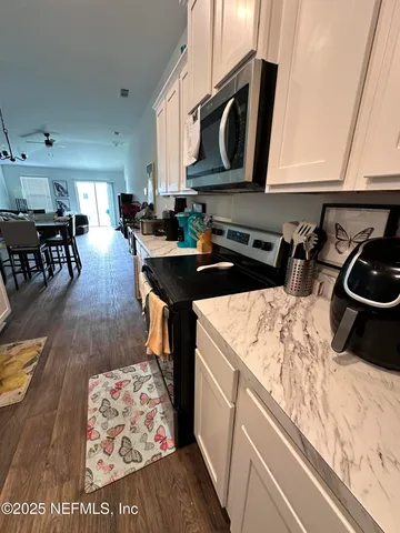 a kitchen with stainless steel appliances kitchen island granite countertop a stove a sink and a microwave