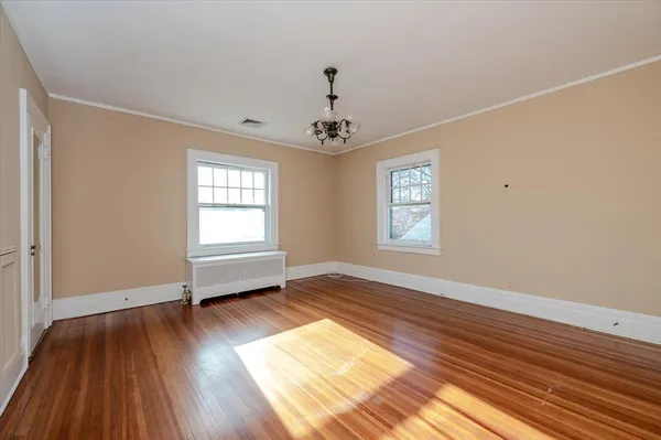 wooden floor in an empty room with a window