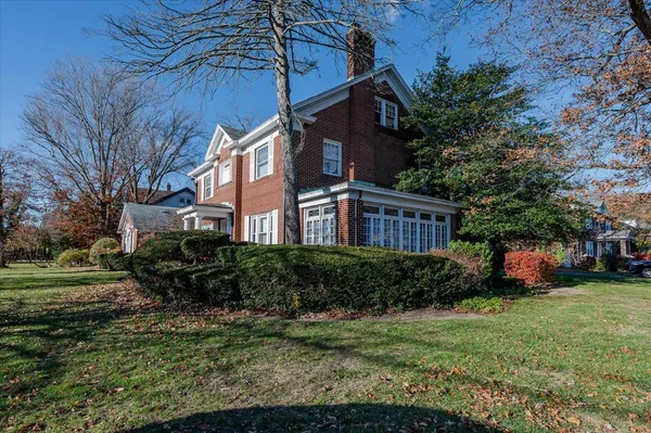 a view of a house with a yard and sitting area