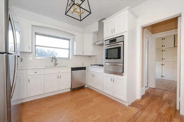 a kitchen with white cabinets and appliances