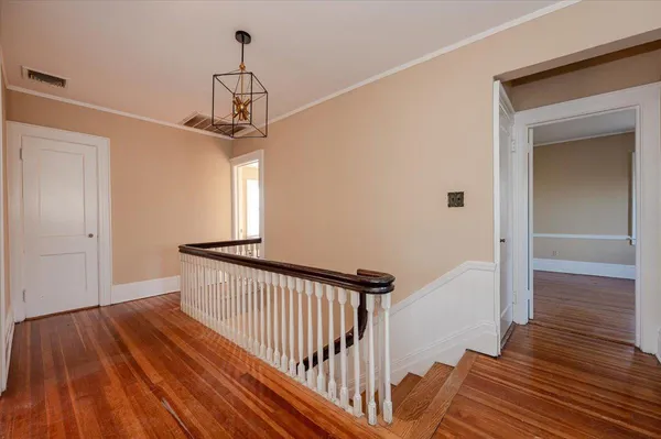a view of a hallway view with wooden floor and staircase