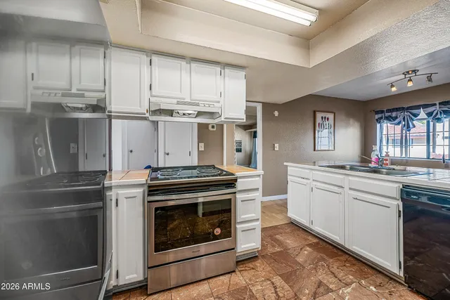 a room with lots of white furniture and a chandelier