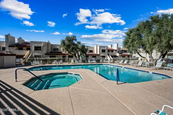a view of a swimming pool with a patio and a yard