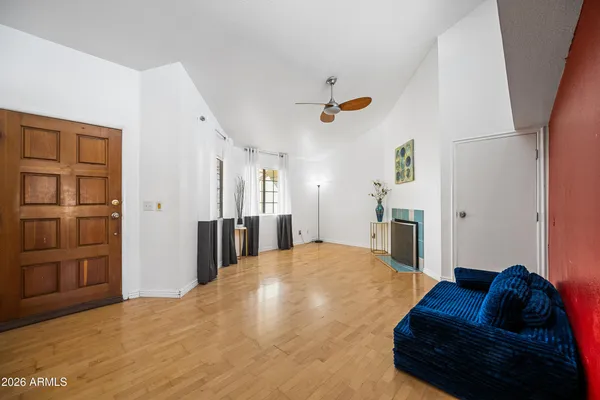 a view of an empty room with window and kitchen area
