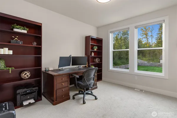 a view of a workspace with furniture and a window