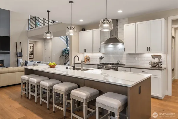 a kitchen with a dining table chairs sink and white cabinets